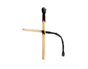 Burnt matches arranged against a black backdrop, forming a cross-like shape