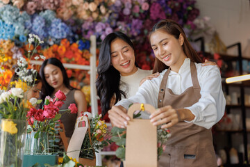 Florist woman preparing flower arrangements with smiling friend