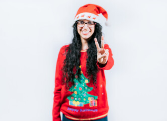 Happy girl in Christmas hat counting number two, isolated. Smiling girl in Christmas sweater counting number 2