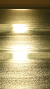 Sunset on a large lake, horizon line and glare on the water.