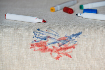 A variety of colorful marker stains cover a light fabric surface.The surface light fabric shows intricate texture as the cleaning care. Daily stains concept.