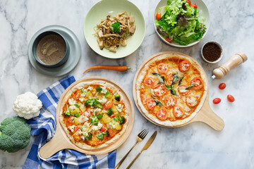Delicious arrangement of pizzas and side dishes on a marble table, top view
