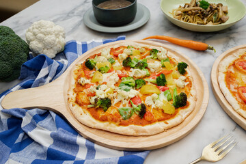 Delicious pizza with fresh vegetables on wooden plate, showcasing a healthy meal