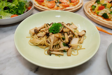 A plate of delicious spaghetti with mushrooms, lettuce, and pizza