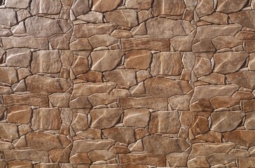 Decorative wall coating made of stonaware with irregular shaped brown stones effect. Background and texture.