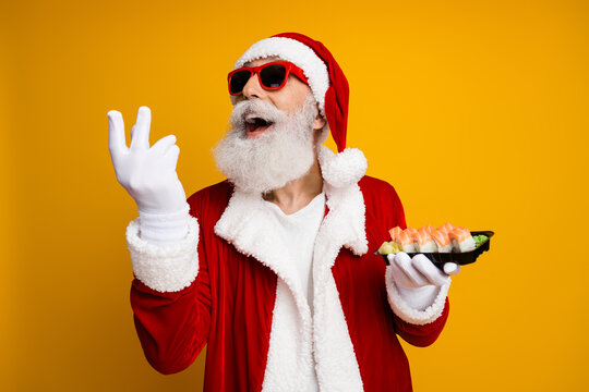 Santa Claus joyfully enjoys sushi while celebrating during the holiday season against a vibrant yellow backdrop embracing Christmas spirit