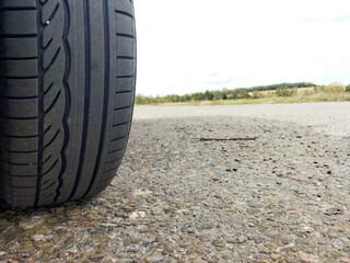 Tire on gravel road under cloudy sky in late afternoon
