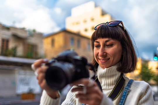 Woman photographer with dslr camera taking pictures outdoors. Girl with camera outdoors. Home hobby, lifestyle.