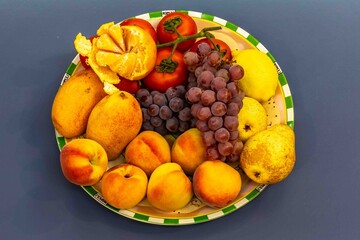 Group of ripe and juicy tropical fruits, grapes, peach, pear, apple, mango, lemon