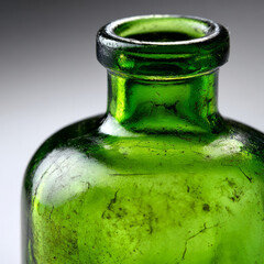Close-up of a vintage green glass bottle with rustic texture.