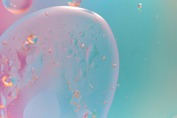 Abstract oil bubbles in water against a gradient background in turquoise and pink tones. Soft light, smooth shapes, transparent texture, and a feeling of lightness. A modern minimalist composition