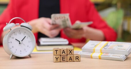 Counting cash and managing time during tax season in a cozy workspace filled with financial documents and preparation - Powered by Adobe