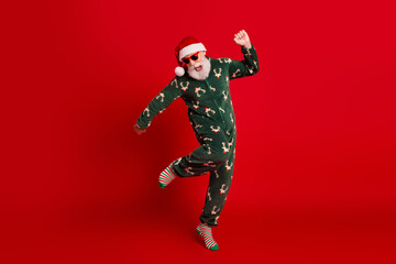 Dancing santa in green reindeer pajama joyful festive vibe against a bold red background perfect Christmas eve