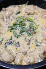 Homemade food, meatballs with spinach in a creamy sauce