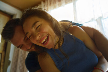 Happy couple hugging and laughing together at home