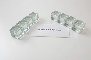 Transparent glass cubes aligned around a See the whole picture message