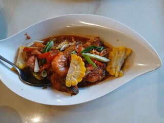 sweet and sour shrimp with sweet corn served on a white plate