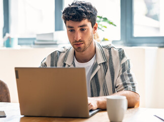 Engineer working on a laptop at startup office in casual clothing