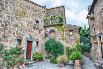 Naklejka premium Ancient Stone Dwellings and Verdant Foliage in Civita di Bagnoregio