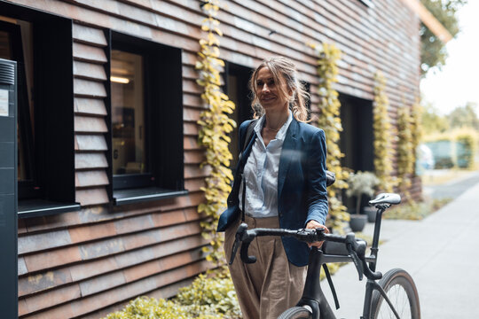 Female entrepreneur cycling to modern office promoting work-life balance
