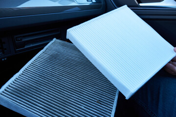 A close-up photo of a car's air filter with a shallow depth of field. The old and new air filters.