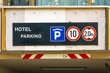 Garage entrance public parking sign on urban street in city