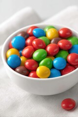 Colorful Candy Coated Chocolate Pieces Filling a White Bowl on Linen Tablecloth Studio Shot Sweet Treat