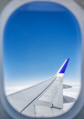 View of airplane wing from passenger seat on a sunny day