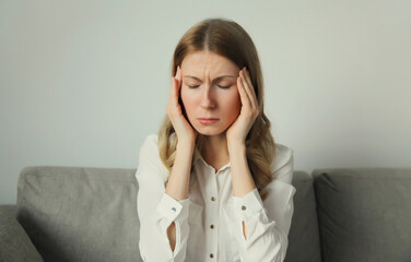 Exhausted tired woman suffering from headache, stress, fatigue, temples pain, migraine, loud noise