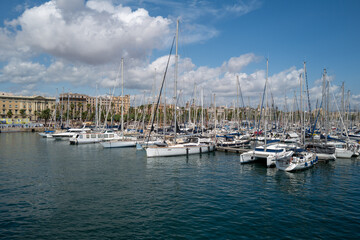 Fototapeta premium Scenic view of a marina filled with sailboats and yachts on a sunny day in a Mediterranean coastal city.