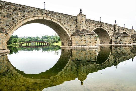 Two beautiful stone bridges arch over calm waters in Dongguan's Songshan Lake