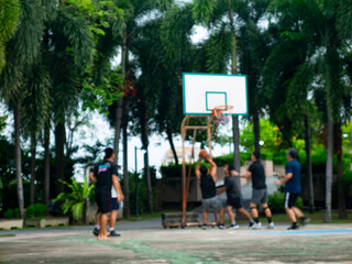 Blurred Basketball Court with Group of People Playing Game Outdoors.
