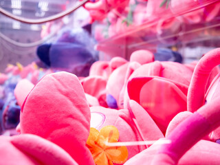 Colorful Pink and Purple Plush Toys Inside Claw Crane Machine at Arcade Game Center
