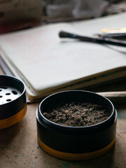 Cannabis Grinder Showing Finely Ground Marijuana with Rolling Papers and Joint