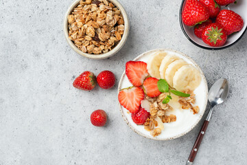 Yogurt bowl with muesli, banana and strawberries. Healthy diet fitness meal for weight loss and wellbeing