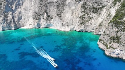 Aerial drone cinematic video of paradise tropical destination island with volcanic caves and white cliffs visited by yachts and sail boats forming a blue lagoon with turquoise crystal clear waters - Powered by Adobe