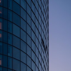 Fototapeta premium Dusk Embrace: Macro Abstract Exploration of A Nightscraper’s Sleek Contours, Reflective Surfaces, and Minimalist Urban Geometry in Subtle Twilight Elegance