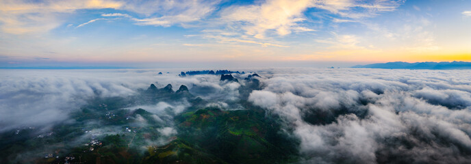 Panoramic view of the majestic mountain landscape and the sea of clouds at sunrise in Guilin, China.