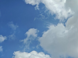 Obraz premium Blue sky with white fluffy clouds creating calm and peaceful atmosphere
