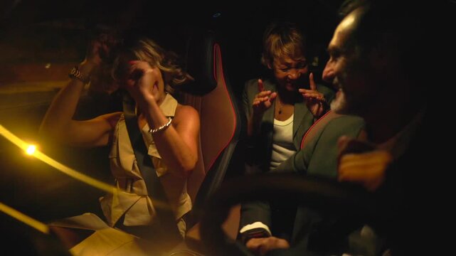 Cheerful mature friends enjoying a night out, laughing, dancing, and singing together while driving through the city streets, having a great time on their way to a party or event