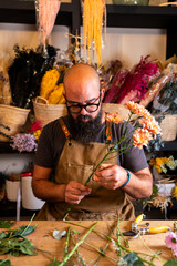 Florist preparing flowers for bouquet in studio
