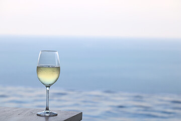 glass of cold white wine on the summer seashore by the water, relaxing by the water, a gentle background of soft color