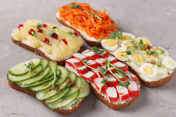 Sandwiches with fresh carrots, cucumbers, pineapple, berries, crab sticks and quail eggs with peas microgreens © Anzhela