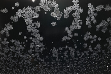 Ice crystals freezing on a black background, abstract winter photo surface