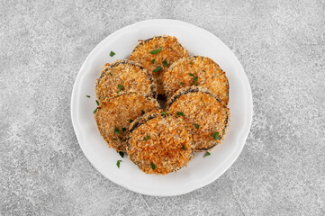 Baked garlic crispy eggplant with tomato sauce on a plate. Vegetarian food. Selective focus, top view.