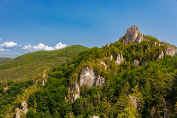 Súľovské skaly, Slovakia. Rocky formations and lush green forest under blue sky, unique limestone towers, needles, and cliffs in scenic mountain landscape, popular hiking and climbing destination.