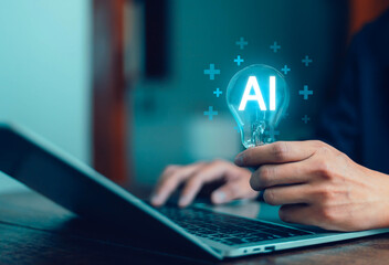 Businessman holding light bulb with glowing AI symbol in front of laptop, representing artificial intelligence, innovation, digital technology, creative idea, smart business solution for the future.
