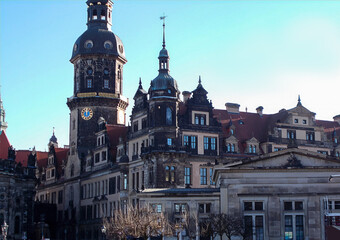 Ornate Renaissance Dresden castle tower and palace with red roof, intricate windows, and subtle winter trees, elegant historic center in clear daylight
