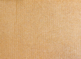 A full-frame texture background of a brown cardboard sheet. This recycled paper surface is ideal for concepts related to packaging, shipping, and eco-friendly materials.
