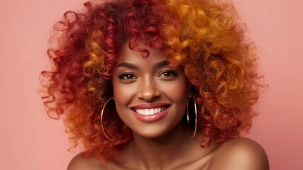 Opening studio shot featuring model smiling, tilting head on peach backdrop with gold hoop earrings - Powered by Adobe